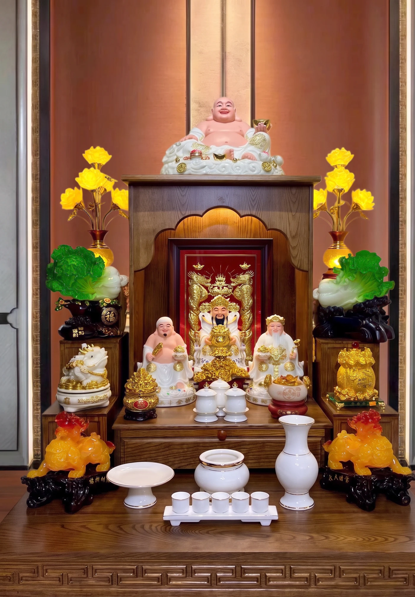 Một bàn thờ Thần Tài bày đầy đủ: đĩa quả bên trái, bát nhang ở giữa, bình bông bên phải, kỷ chén phía trước
